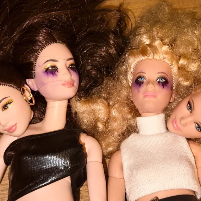 the kill 2 cover art: fashion dolls with smeared purple eye makeup, piled together