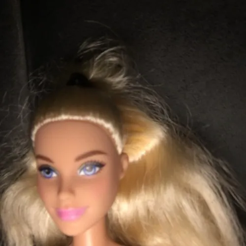 gossip girl cover art: a blonde barbie doll close up in the dark
